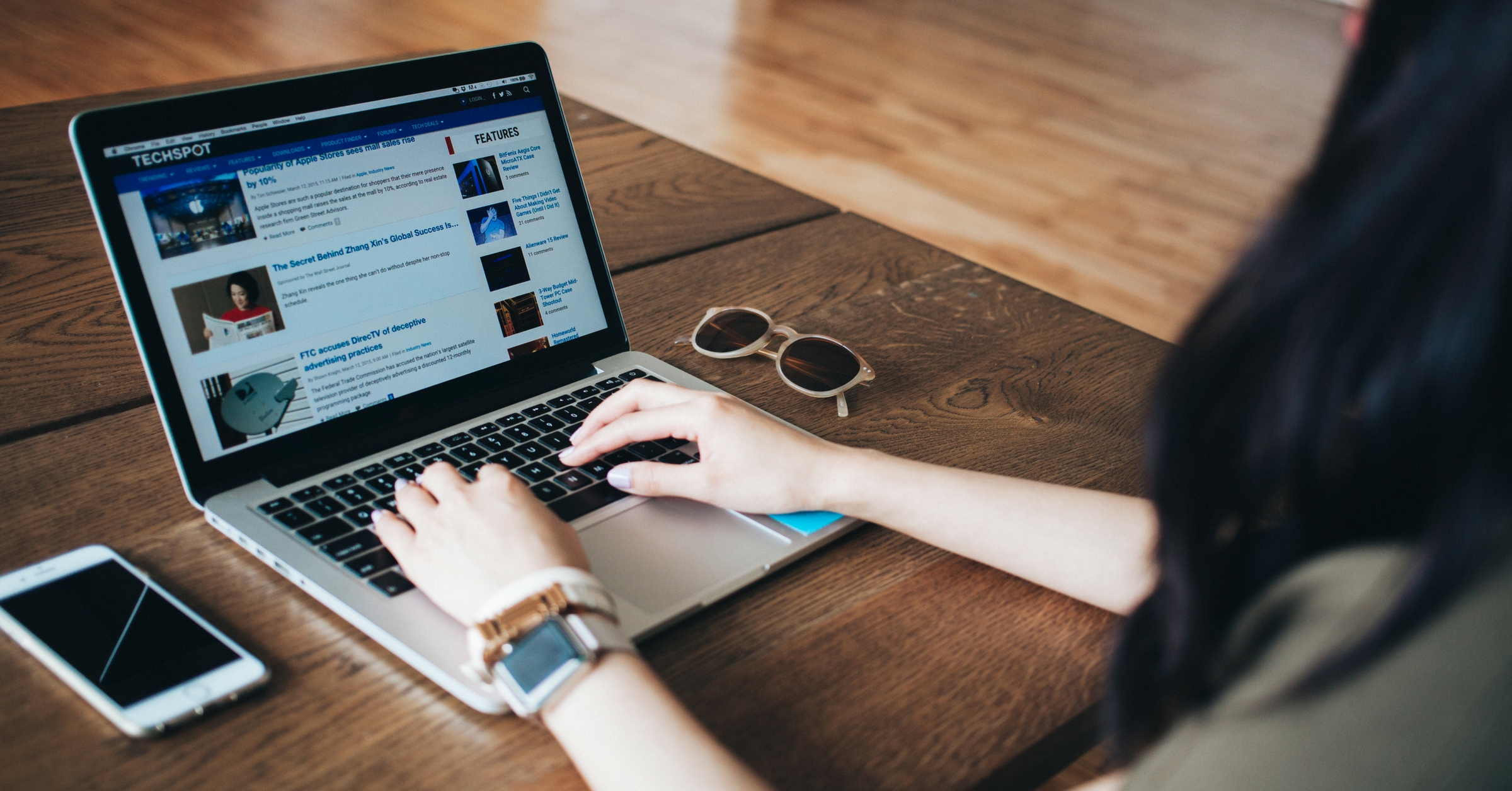 image showing woman looking at a laptop with hands on the keyboard