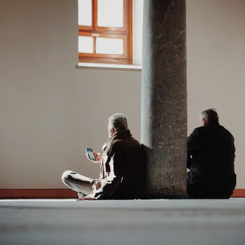 Two people sitting on the ground seeing programmatic advertising on their smartphones